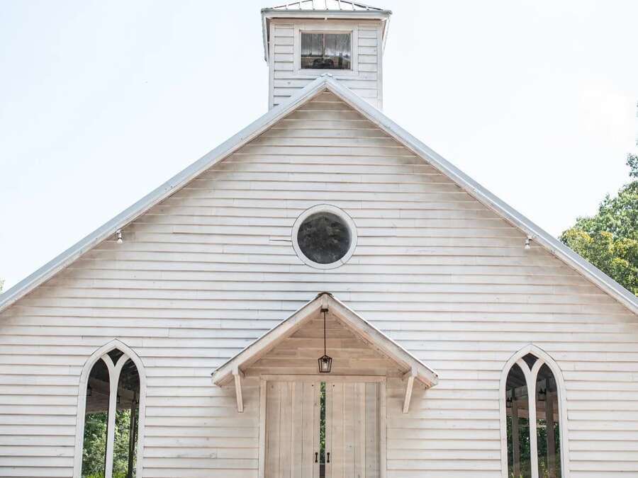 A small white clapboard chapel with arched windows and a cupola.