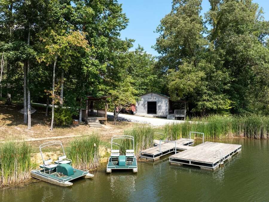 A dock on the lake with paddle boats tied alongside.