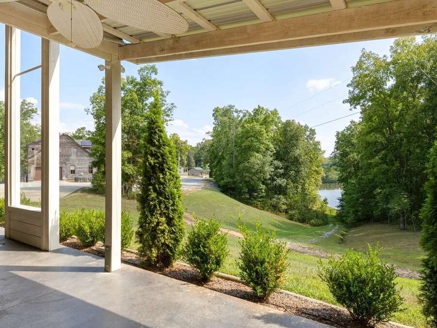 A long covered porch looking out over the lawn toward the water.